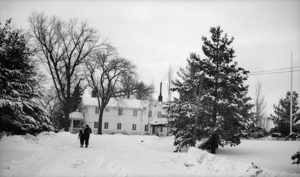 Two people walk down the driveway of the Dell View Hotel on a winter day.  The photo was taken by Ruth Bennett Dyer.