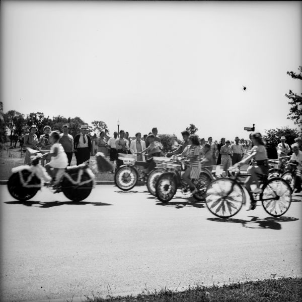 People riding decorated bicycles in a 4th of July parade.
