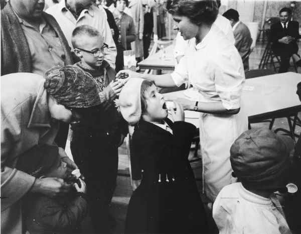 A nurse gives children the sabin oral vaccine.