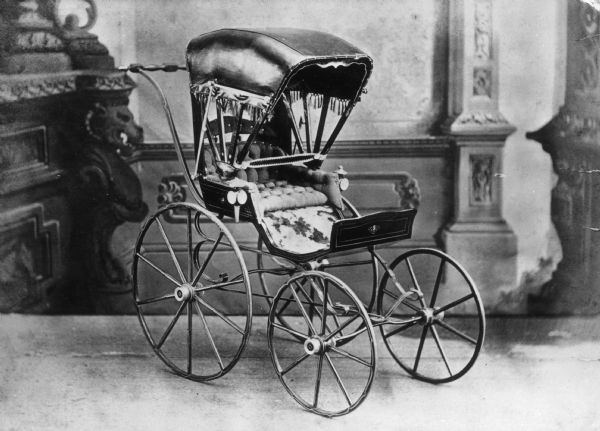 Children's carriage with fringed canopy produced at children's carriage factory.