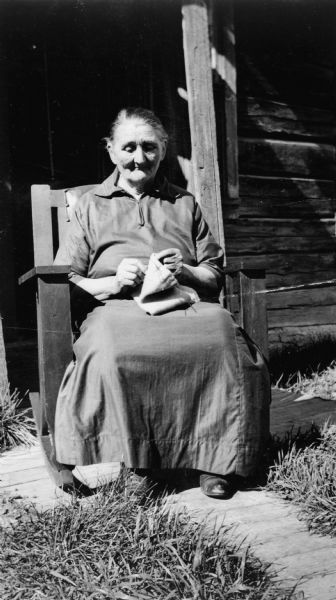 Maria Getto seated in rocking chair in front of home, Oulu Township.