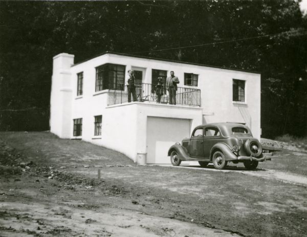John and Stanta Bordner's Crestwood home shortly after construction. The home stands at 5746 Bittersweet Place. Three people stand on a porch above the garage wtih a car in the driveway.