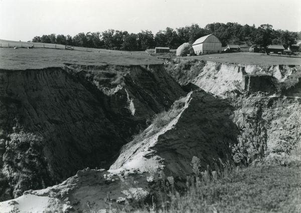 T. N19 R. 4W about section 19, McPeak farm. A 50 foot deep ravine is seen rapidly eating its way toward farm buildings.