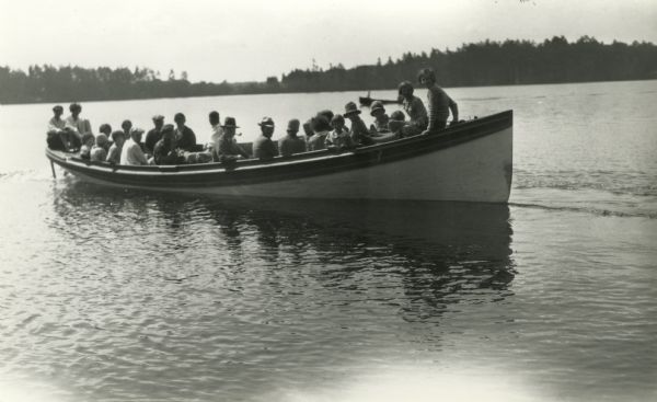 Large group of guests at Warner's Resort, Plum Lake, enjoying a boat ride.