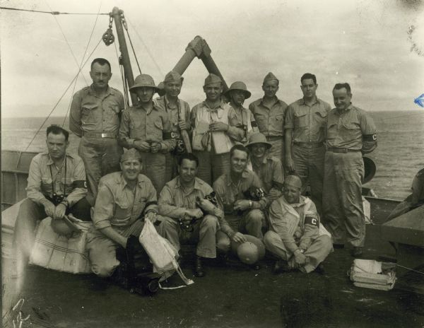 Group portrait of war correspondents and photographers on a ship on their way to Australia, February-March, 1942.  Byron Darnton, reporter for the New York Times, is on the right in the back row.