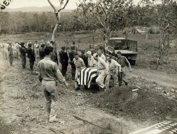 Byron Darnston coffin being borne to the grave by war correspondent pallbearers; Bomana Military Cemetery, Port Moresby, New Guinea.