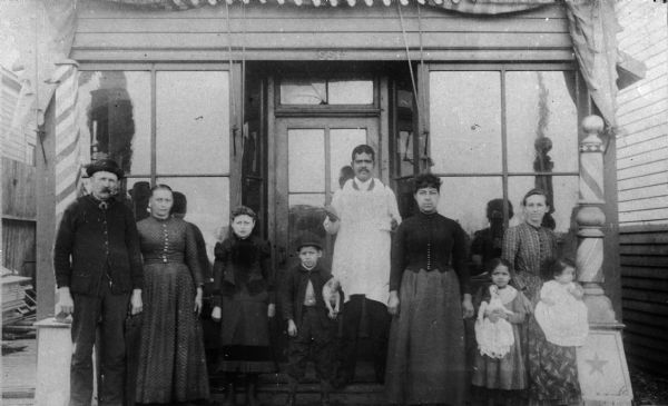 The Shivers family poses in front of the family barbershop. From left to right are Claude Shivers, Rebecca Ann Shivers, Nettie Shivers, unknown, Ashley Shivers, unknown, unknown and Oscar Shivers.