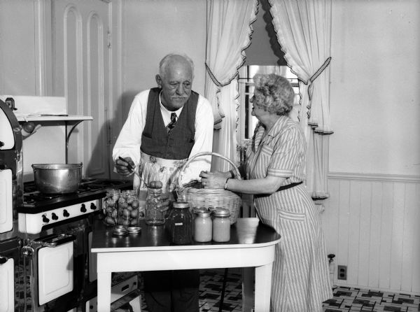 Governor Walter Goodland and his wife Madge in their kitchen pickling pears.