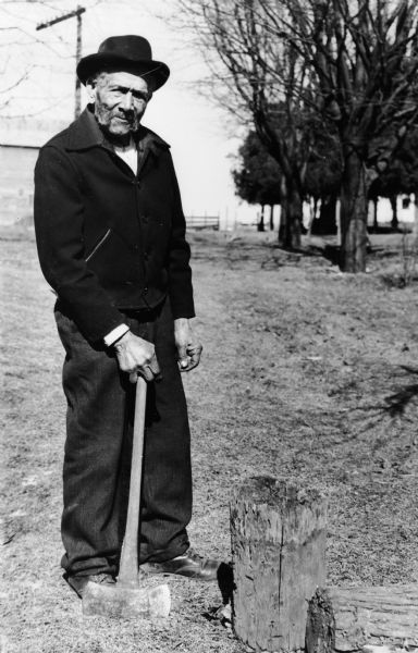 Outdoor portrait of Charles Edward Shepard posing with an axe.