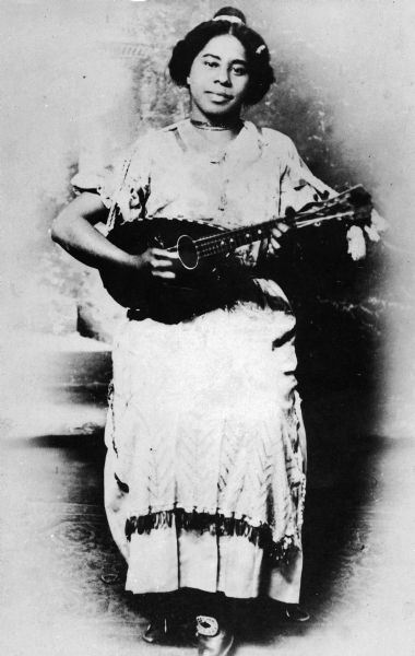 Portrait of Minnie Owens, daughter of pioneer settler Nathaniel Owens, posing with a stringed instrument. She performed in Kentucky Juvenile Minstrels.