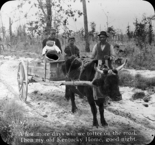 A family posing with an oxcart. Text at the bottom of the image reads "A few more days we will totter on the road, Then my old Kentucky Home, good night.".