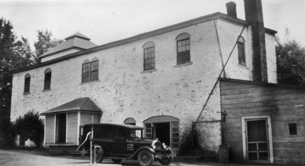 Exterior view of the Shullsburg Brewery with a car parked in front of the building.