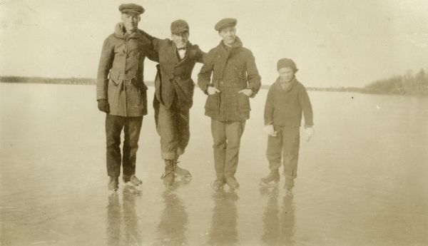 Ice skaters posing in a row on a frozen lake (possibly Big Chetac Lake). On the far right is Thomas Oliver Mattis and next to him is (probably) George Mattis, Jr.