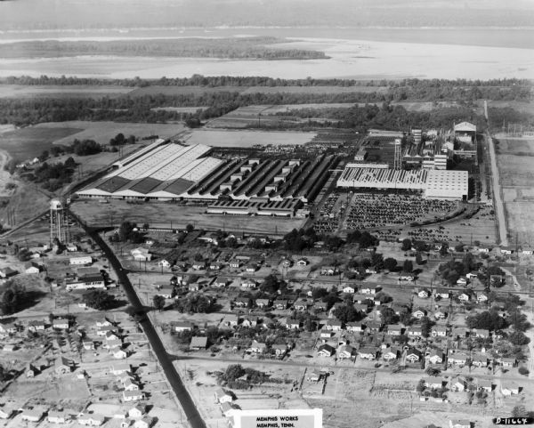 An aerial view of the International Harvester Memphis Works in Memphis, Tennessee, with a view of the surrounding neighborhood and Loosahatchie River. The factory, built to assume production of many items from Chattanooga Plow Works, was in operation from 1946 to 1985, and produced cotton machines, balers, disk plows, harrows, listers and middlebusters, cutters, toolbars and bedders, and lister cultivators.The Memphis Works closed in the eighties as part of International Harvester's restructuring process and eventual sale of agricultural equipment line to J.I. Case Company.