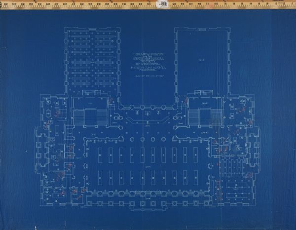 Floor plan for the second floor library and offices of the State Historical Society building designed by architects Ferry & Clas and constructed in 1900. Floor plans indicate proposed furniture arrangement. Red annotations indicate new room numbers.
