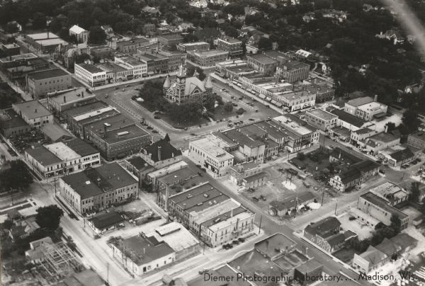 Aerial view of commercial section of Monroe, WI. Green County Courthouse is pictured in the middle of the town square.