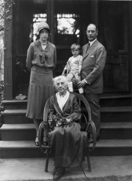 Four generations of the Jackson family, identified as: (seated) Mrs. James A. Jackson (Syndonia Hobbins Jackson), standing left to right, Harriet Jackson Morris and Joseph W. Jackson holding his grandson Thomas Morris. They are probably standing on the steps of the Jackson residence, 323 North Carroll Street.