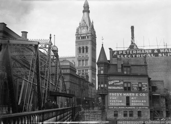 A bridge crosses the Milwaukee River on Oneida Street, now known as Wells Street, looking toward the City Hall tower.