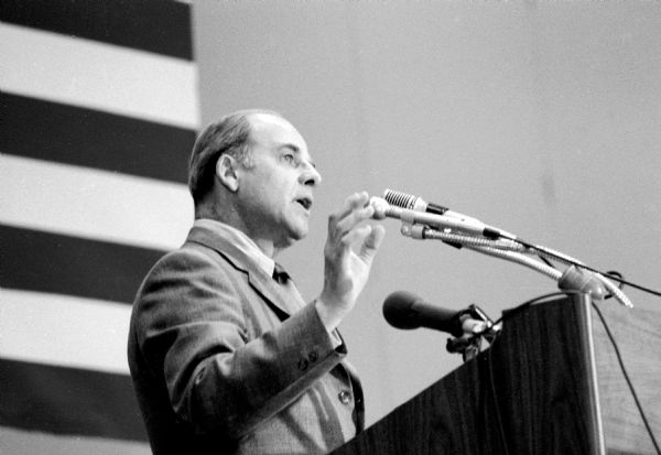 Gaylord Nelson speaking at a podium on Earth Day.