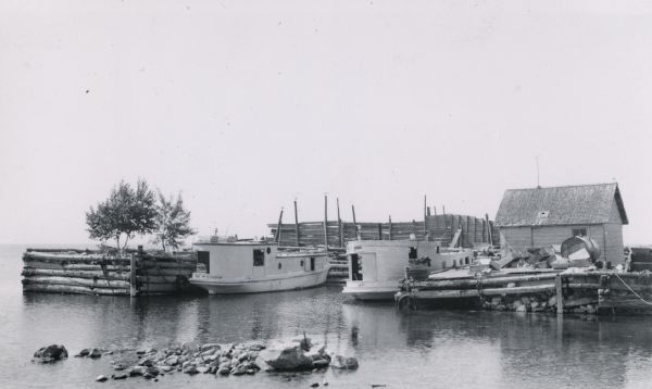 Dock with two fishing boats and other various fishing implements.