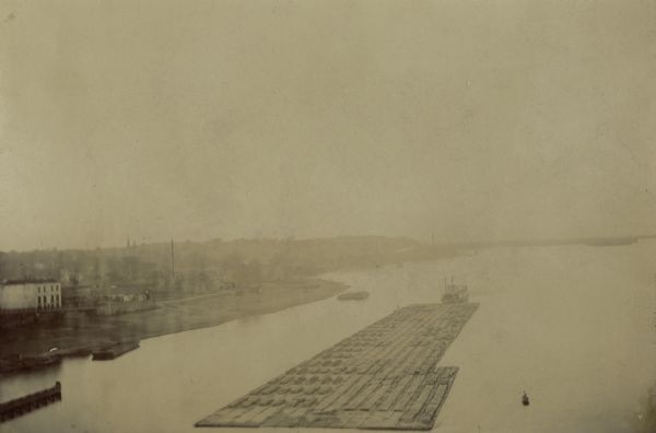 Elevated view of lumber raft on the Upper Mississippi River with shoreline in the background.