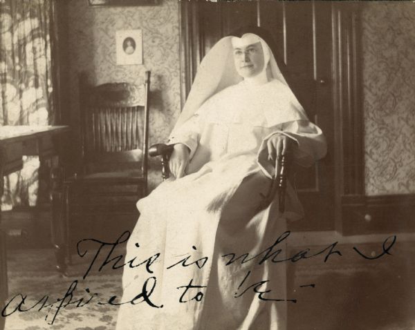 A nun is seated in a rocking chair. Note on photograph reads, "This is what I aspire to be".