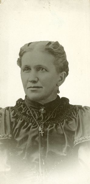 Portrait of midwife Mary Gerrard wearing a cross necklace.