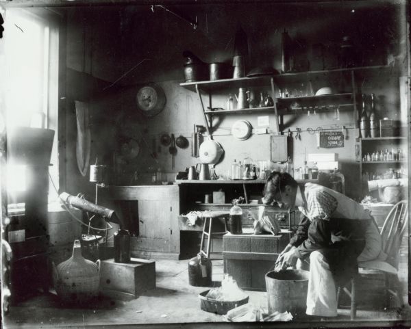 Man washing and filling glass bottles at the Brenneche and Bergmann Pharmacy.