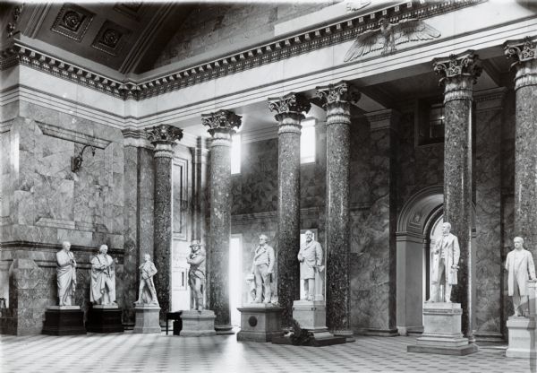 Interior of the National Capitol in Washington, D.C. In a marble decorated room, there are marble statues of men representing each state.