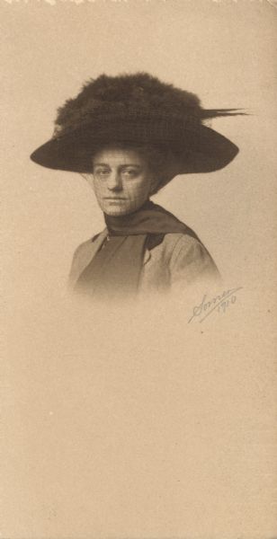 Portrait of woman wearing a large hat with veil.