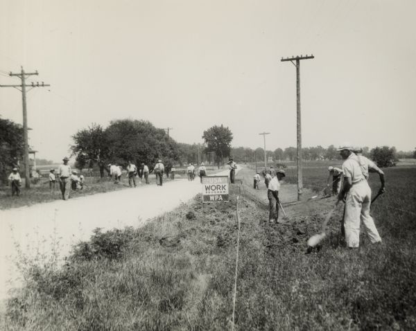 Workers toiling in the sun on the roadside, as a part of the Works Progress Administration (WPA). As a program of the New Deal, it was provided to create jobs and boost the American economy.