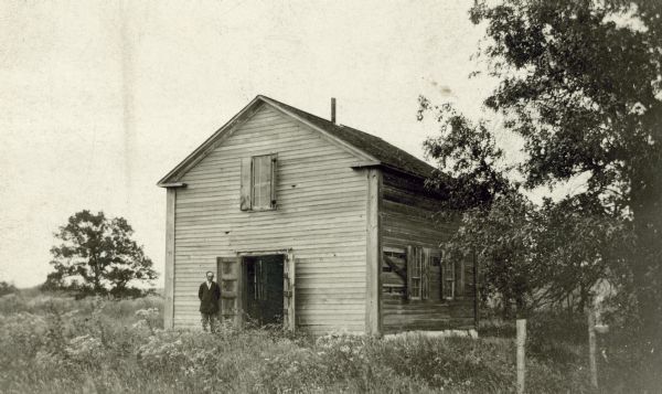 Exterior view of the Norwegian Hauge Church with a man posing at the front door. The church was built in 1852.