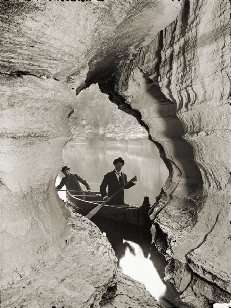 View out to the river from Boat Cave. At the entrance of the cave are two men in a canoe. H.H. Bennett's brother, John, is the paddler in the bow of the boat.