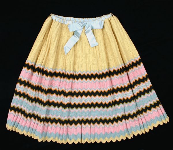 Petticoat knitted of yellow, pink, blue, black, and white wool yarn, with a ribbon belt.