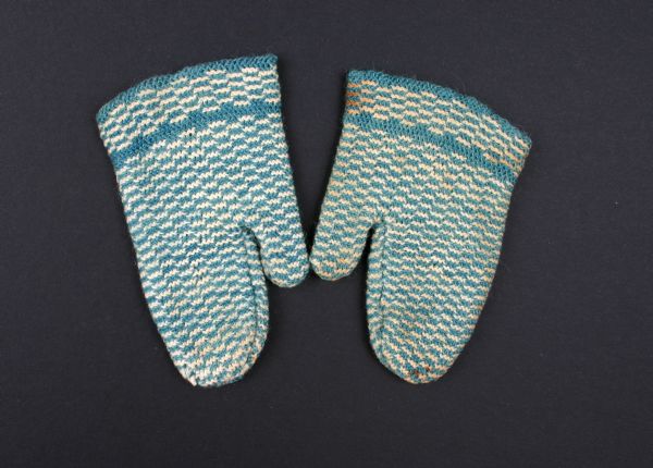 Baby mittens knitted of blue and white wool yarn.