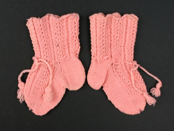Baby booties knitted of pink wool yarn.
