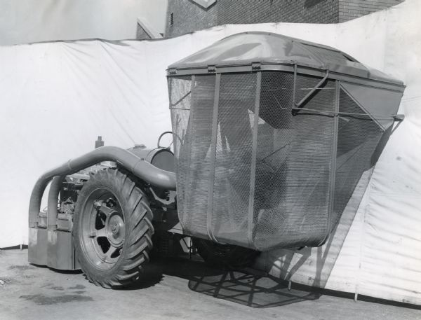 Engineering photo featuring the storage basket of an experimental 2-row cotton picker mounted on a Farmall "H" tractor.
