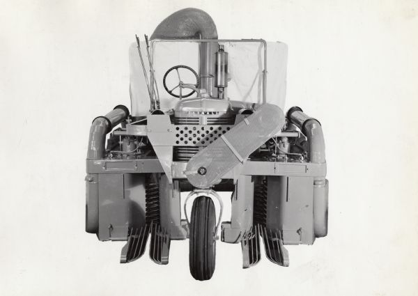 Engineering photograph of an experimental 2-row, single drum cotton harvester [picker] mounted on a Farmall "B" tractor.