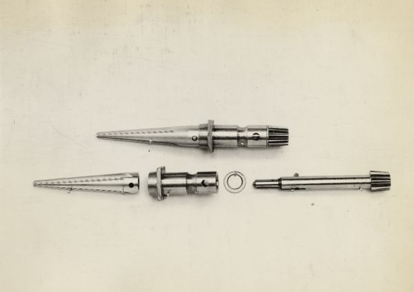 Engineering photograph of a cotton picker finger, spindle, washer, and removable bushing.