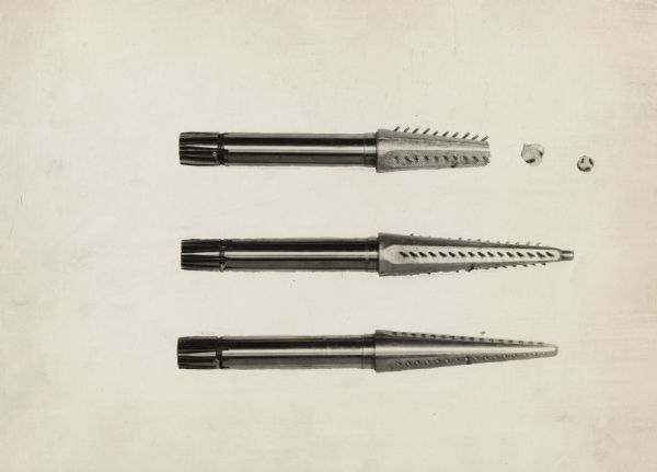 Engineering photograph showing three views of a cotton picker spindle with inserted pins.
