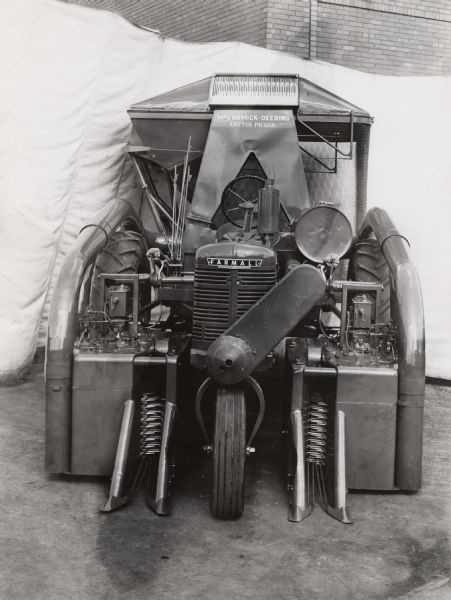 Engineering photograph of an experimental 2-row cotton picker on a Farmall "H" tractor.