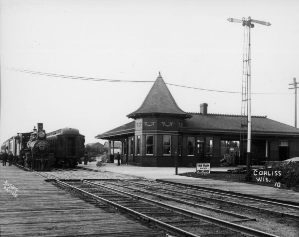 Exterior view of the train depot with two trains on the tracks.