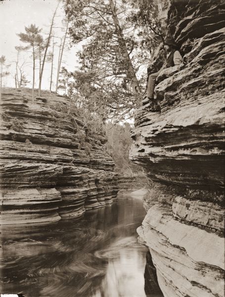 Channel behind Steamboat Rock, from a steamboat. Man sitting on rock ledge on right.
