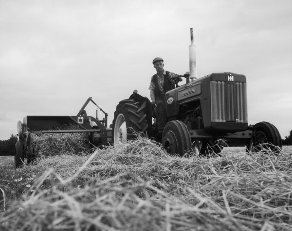 A man pulls a baler with a British-made B 414 diesel tractor.