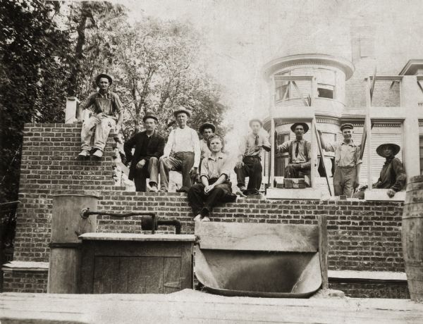 Men pose in front of the University Club, 803 State Street, which is  under construction. William F. Steuber, Sr. is the third man from the left.