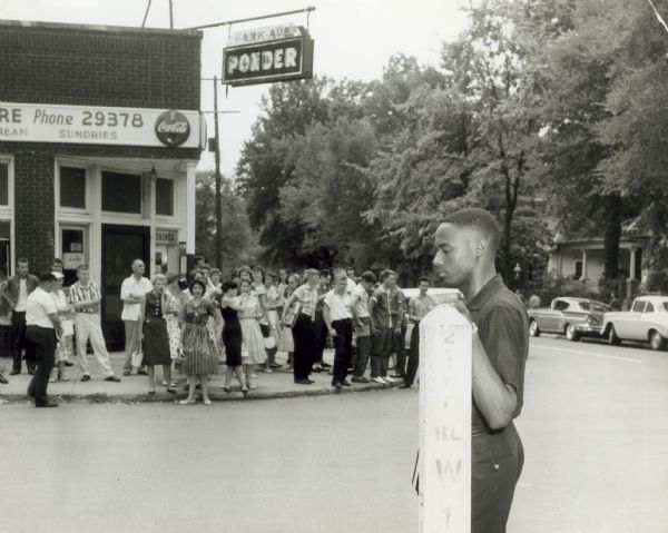 Jefferson Thomas of the Little Rock Nine is harassed by Central High School students as he waits for transportation after the first day of school.