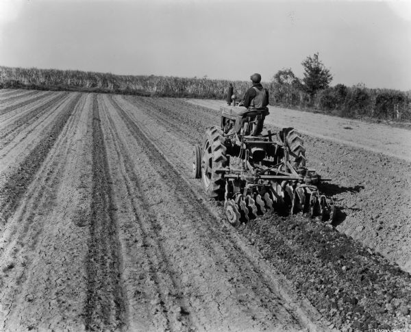The caption for this photograph states that this Farmall MV tractor is "shown at work on the 2800-acre Triangle Farm near McCall, Louisiana, some 1800 acres of which was in sugar cane."