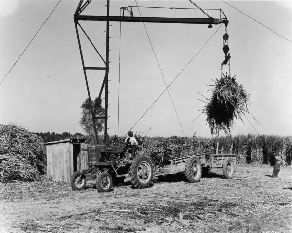 The caption states the "Farmall MV shown is owned by C.R. Tschirn of Donaldsville, Louisiana, who operates a 350-acre farm, 225 acres of which were in sugar cane."