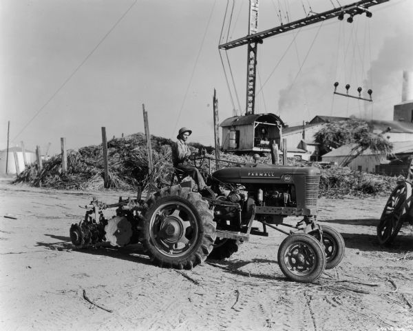 The caption for this photograph states that this Farmall MV tractor is "shown at work on the 2800-acre Triangle Farm near McCall, Louisiana, some 1800 acres of which was in sugar cane."