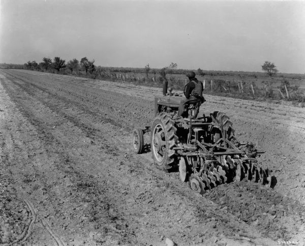 The caption for this photograph states that this Farmall MV tractor is "shown at work on the 2800-acre Triangle Farm near McCall, Louisiana, some 1800 acres of which was in sugar cane."